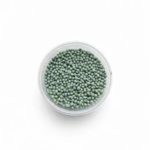 Slow release fertiliser granules in green pellet form in clear container on white background