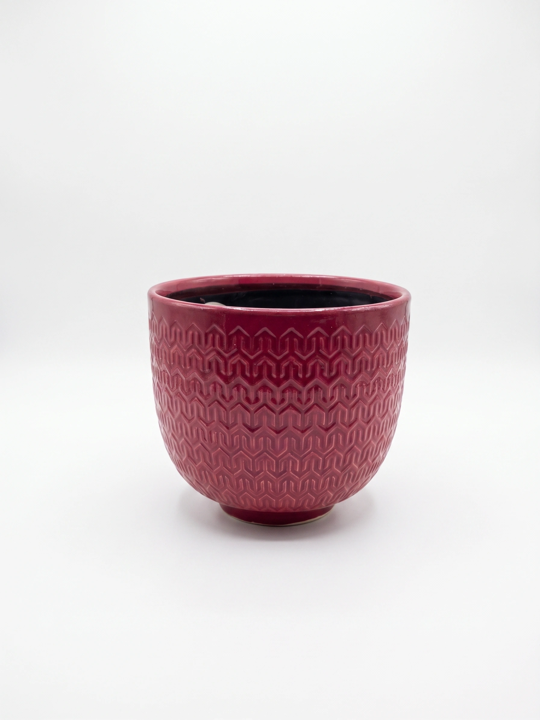 Red pattern ceramic cover pot with embossed geometric design and glossy finish 18cm high by 19cm wide on white background